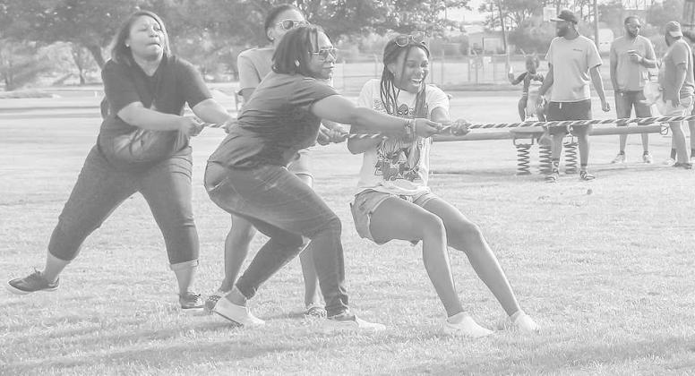 CHILDERS SISTERS- Sisters Joy, Patiance, Charity and Meekness Childers played a game of tug war last Friday during the 33rd Annual Juneteenth celebration. The evening festivities also included bingo, dominos, karaoke and a dance. (Staff Photo by Victoria Brynes)